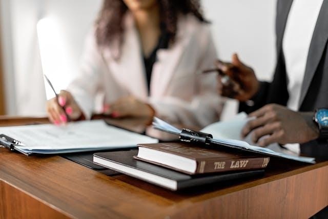 Law book and clipboards on a podium with two people blurred in the background